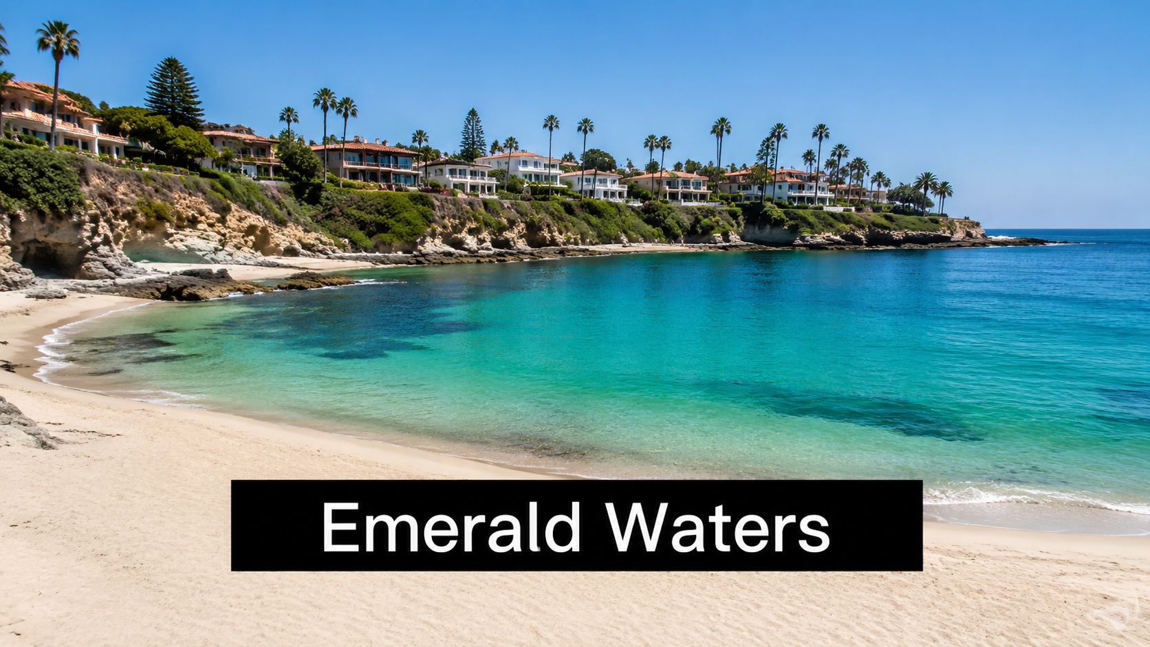 A beautiful sandy beach with clear turquoise water and luxurious houses on the cliffside in California.