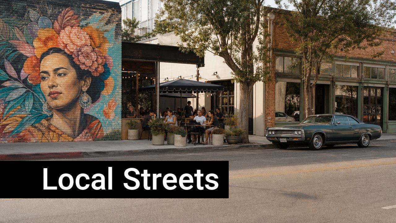 A vibrant mural of a woman next to an outdoor cafe on a sunny street scene.