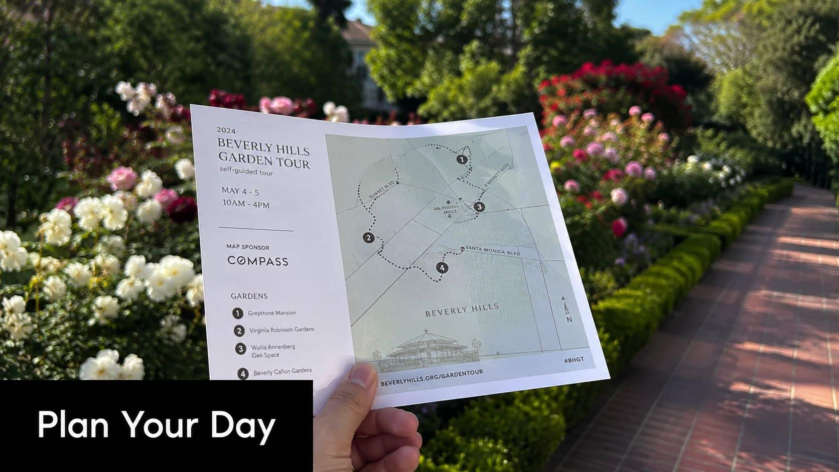 A person holds a map of the 2024 Beverly Hills Garden Tour in a scenic rose garden.