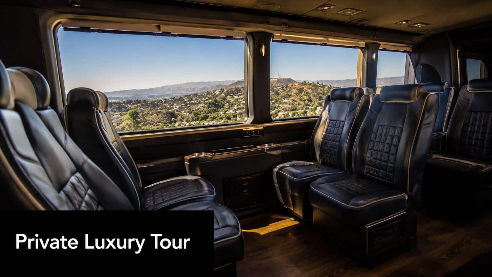 A view from inside a luxury tour bus looking out toward the scenic Hollywood hills in California.