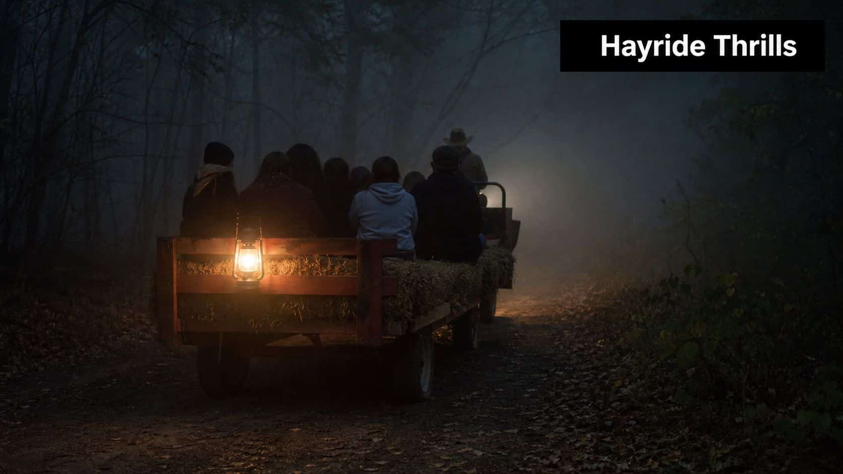 A group of people sitting on a hayride trailer moving through a dark, foggy forest at night.