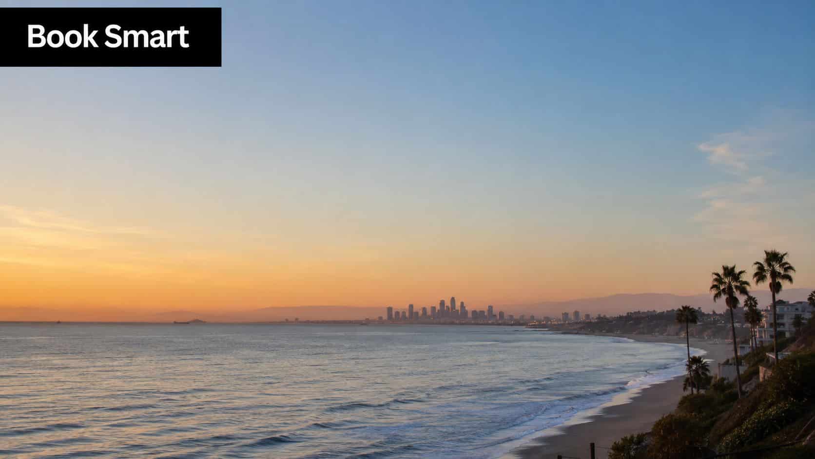 A scenic sunset view of the Los Angeles coastline and city skyline overlooking the Pacific Ocean.